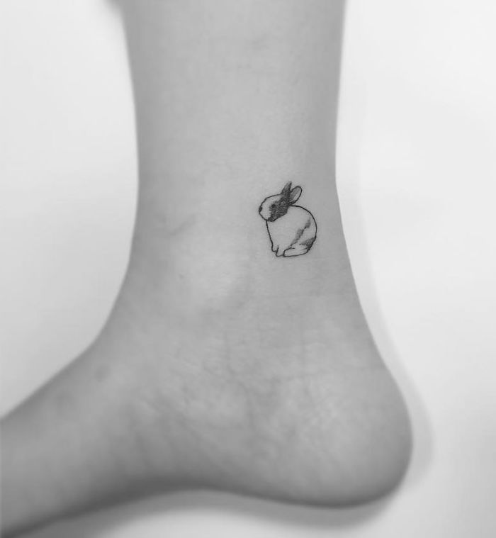 Minimalist rabbit tattoo on the lower leg for women