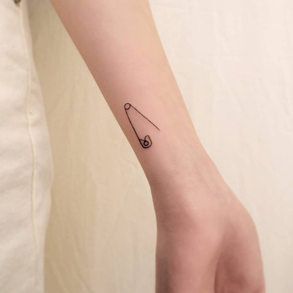 Pins tattoo on forearm for women