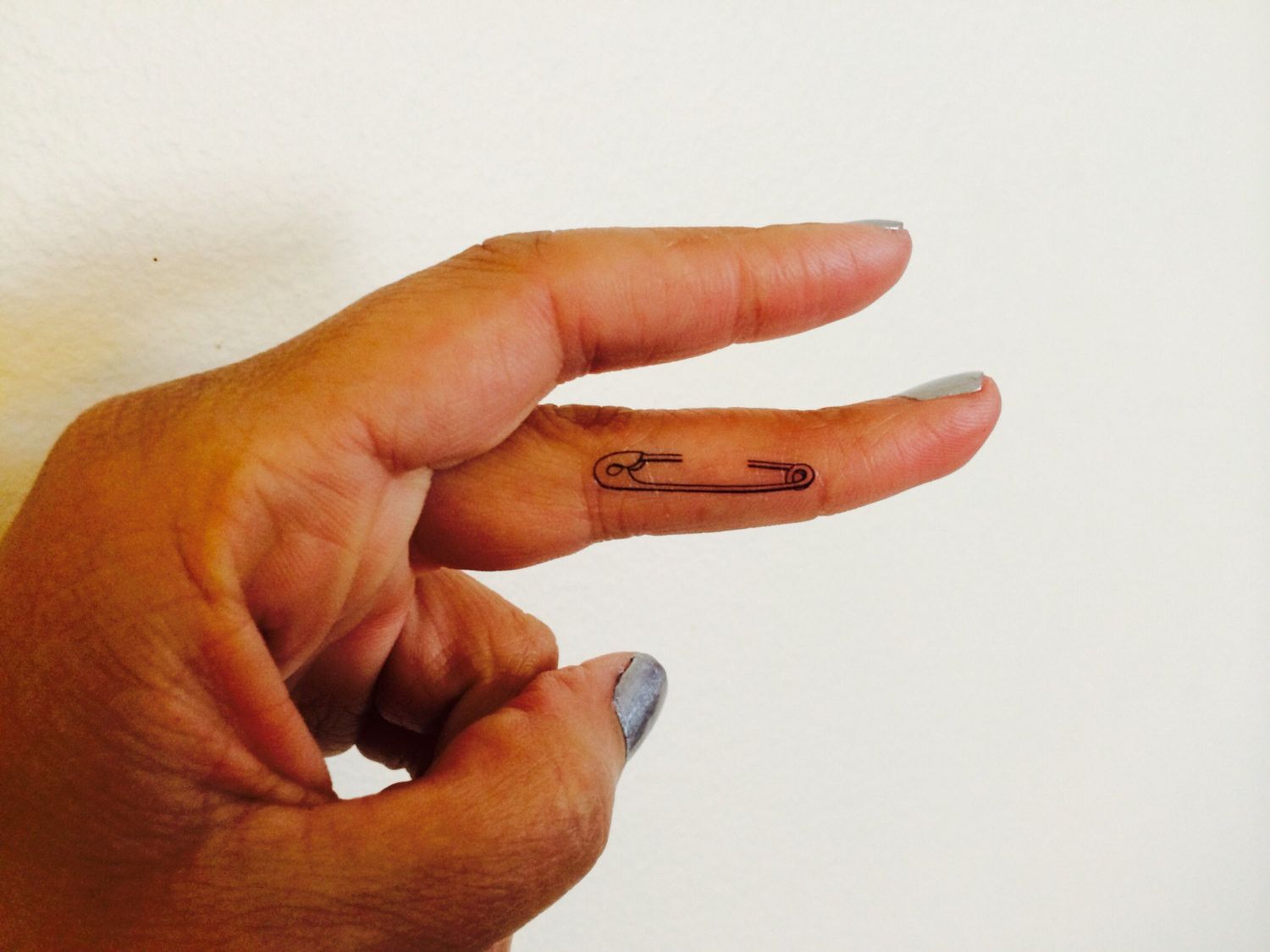 Pin tattoo on the finger for women