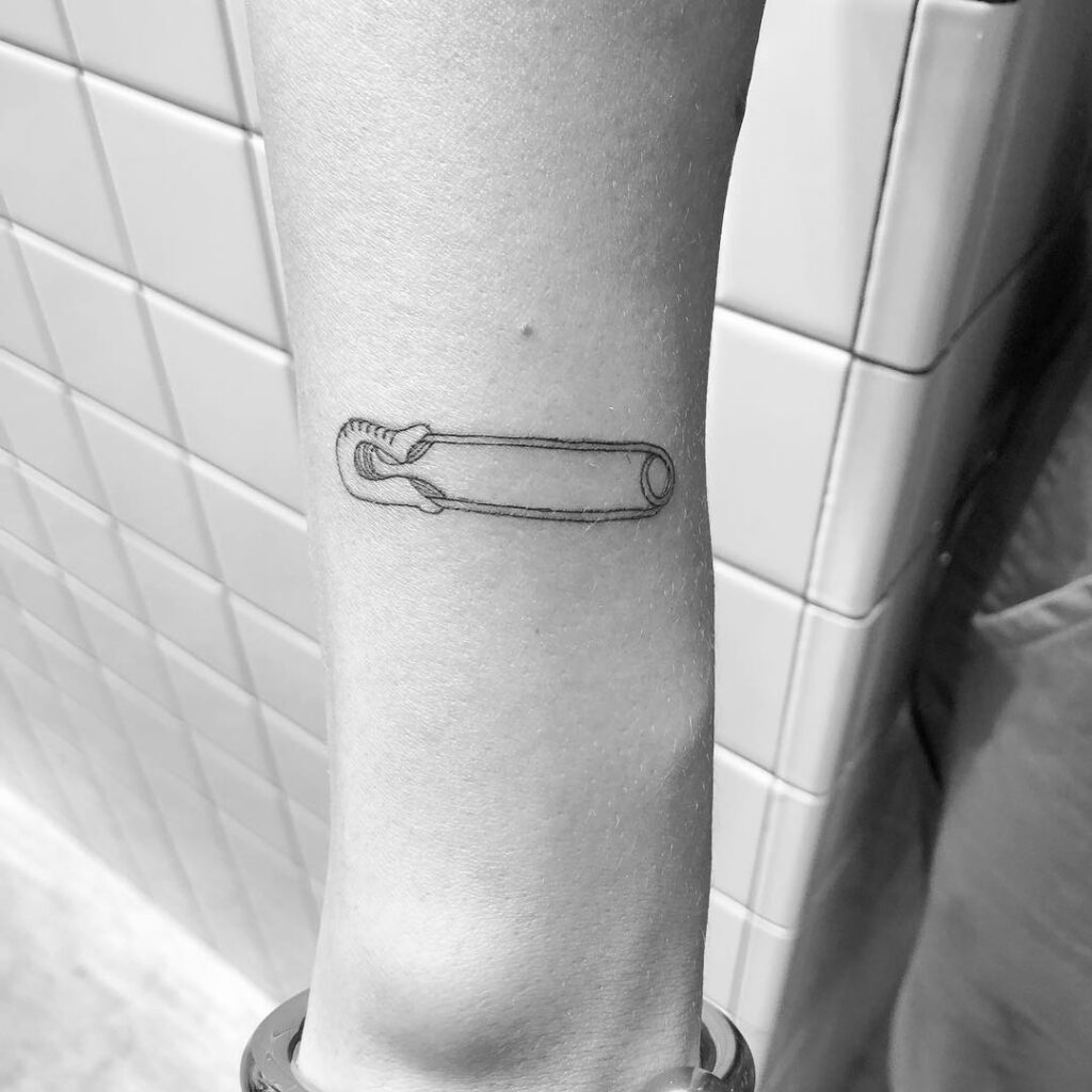 Pin tattoo on arm for women