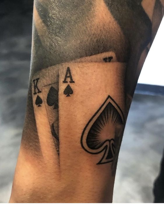 Tattoo of playing cards on the arm for men