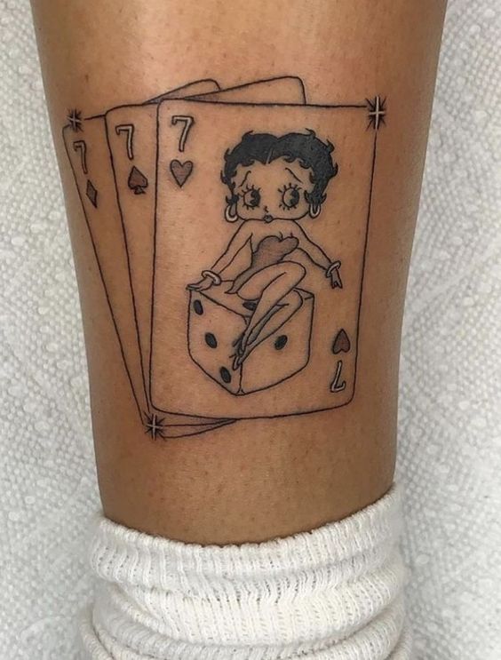 Tattoo of playing cards on the shin for women