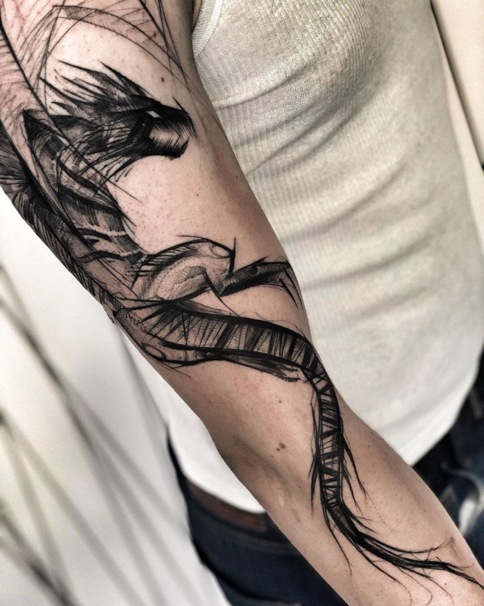 Sketch style dragon tattoo on the arm for men