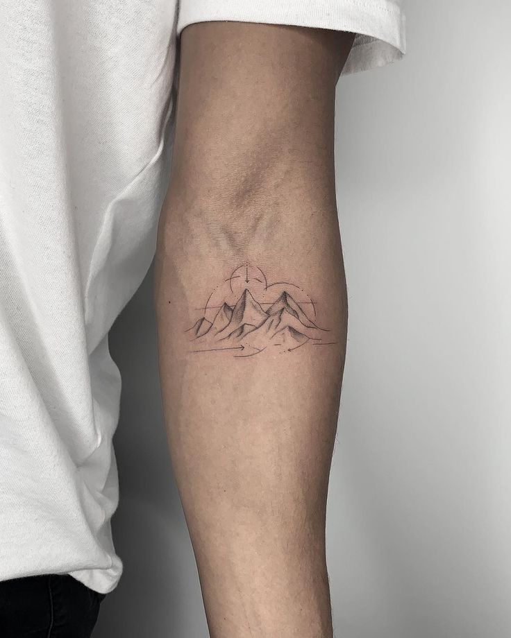 Minimalist mountain tattoo on the forearm for men