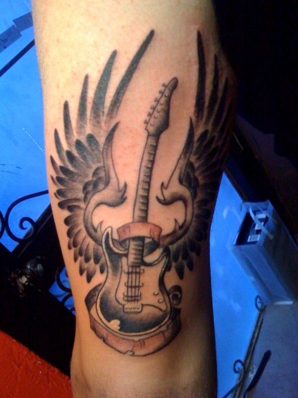 Guitar tattoo with wings on the shoulder for men