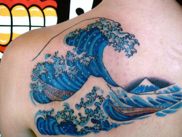 Large wave tattoo on the shoulder blade for men