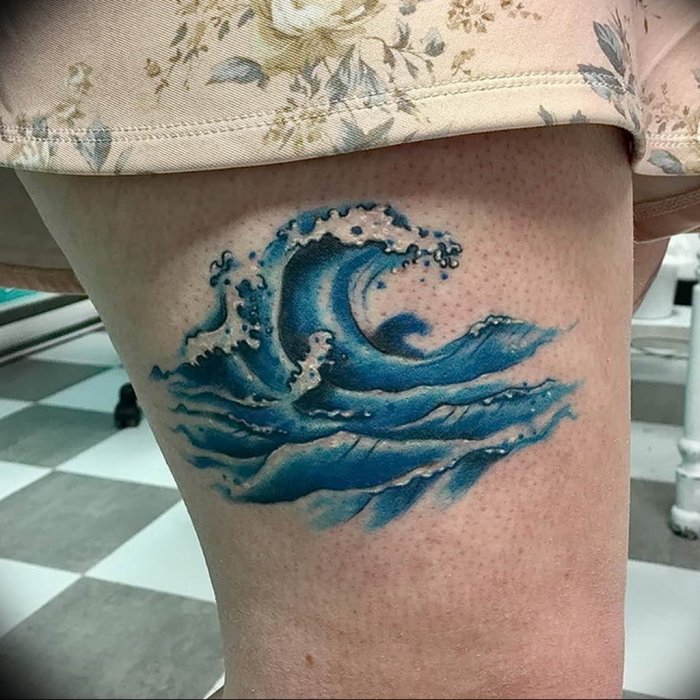 Wave tattoo on thigh for women