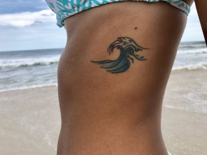 Wave tattoo on the side for women