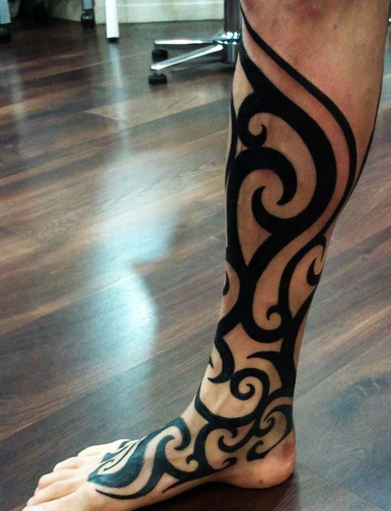 Tribal style tattoo on the shin for men