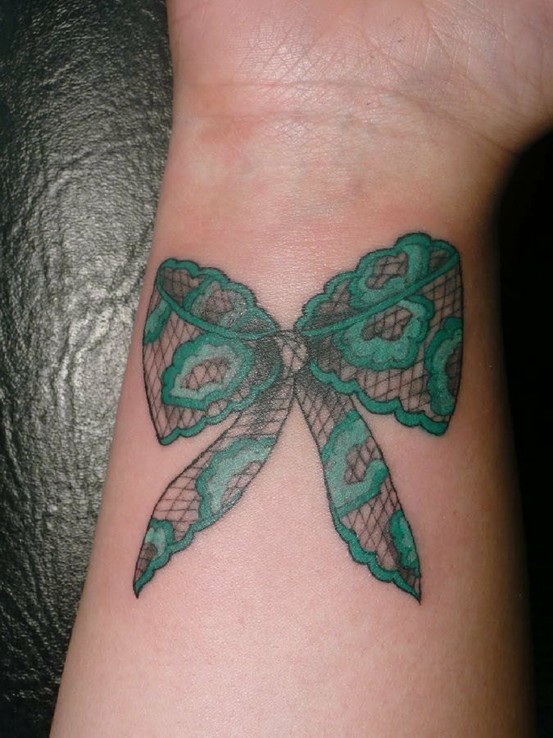 Bow tattoo on arm for women