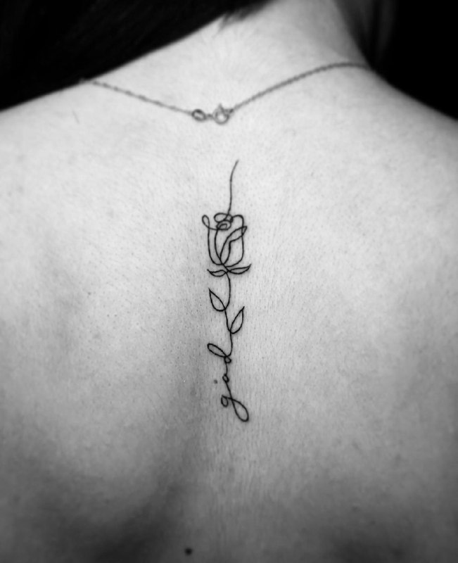 Minimalist rose tattoo on the spine for women