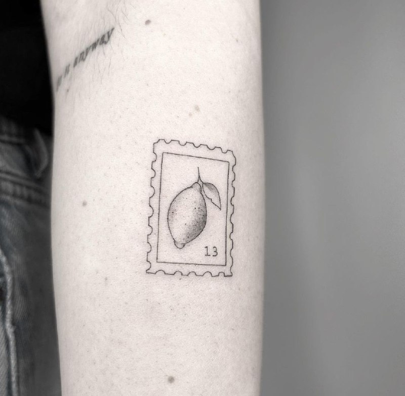 Minimalist lemon tattoo on the arm for men