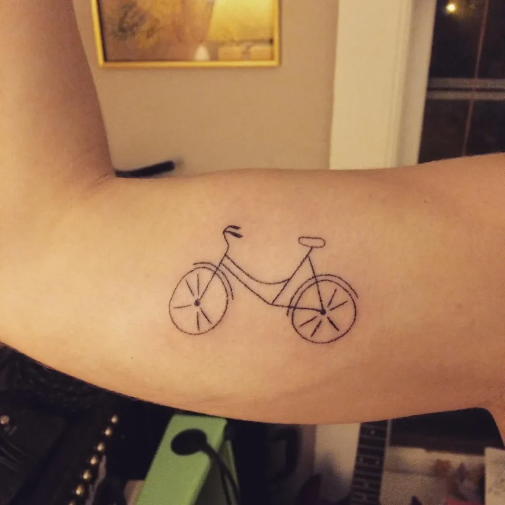 Bicycle tattoo on biceps for men