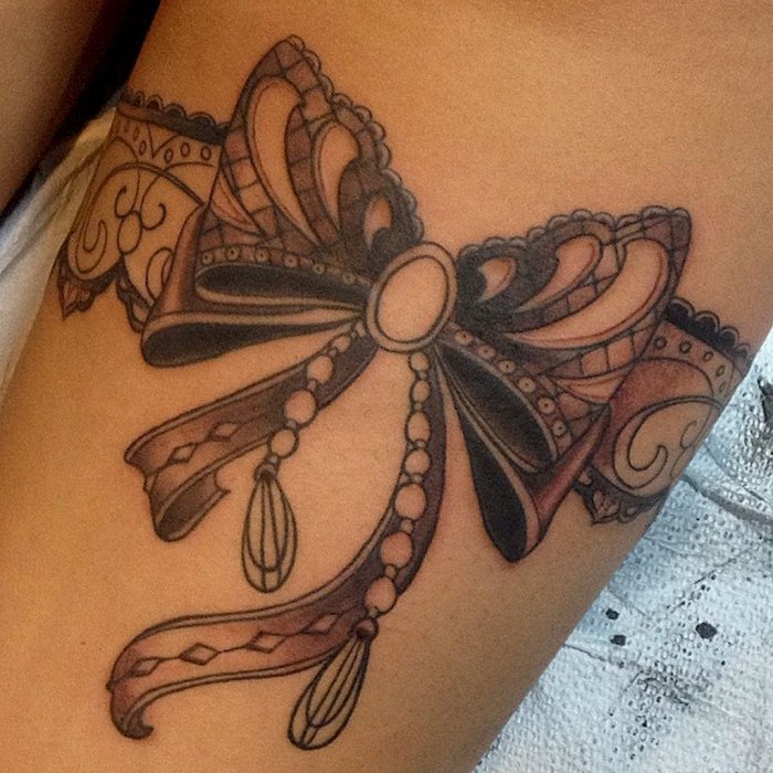 Bow tattoo on leg for women