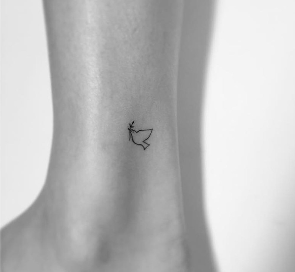 Minimalist style tattoo on the lower leg for women