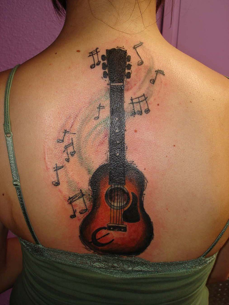 Large guitar tattoo on back for women