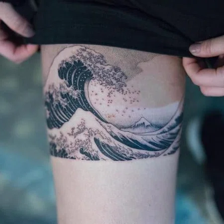 Wave tattoo on thigh for women