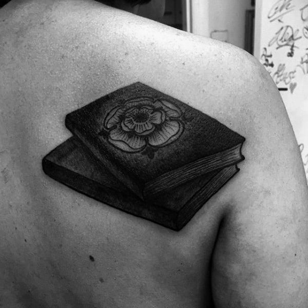 Book tattoo on the shoulder blade for men