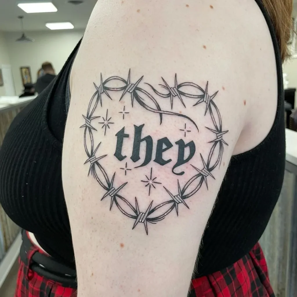 Barbed wire tattoo with writing on shoulder for women