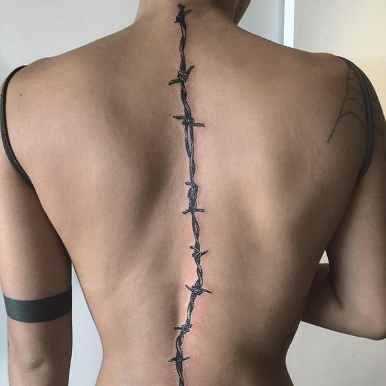 Barbed wire tattoo on spine for women