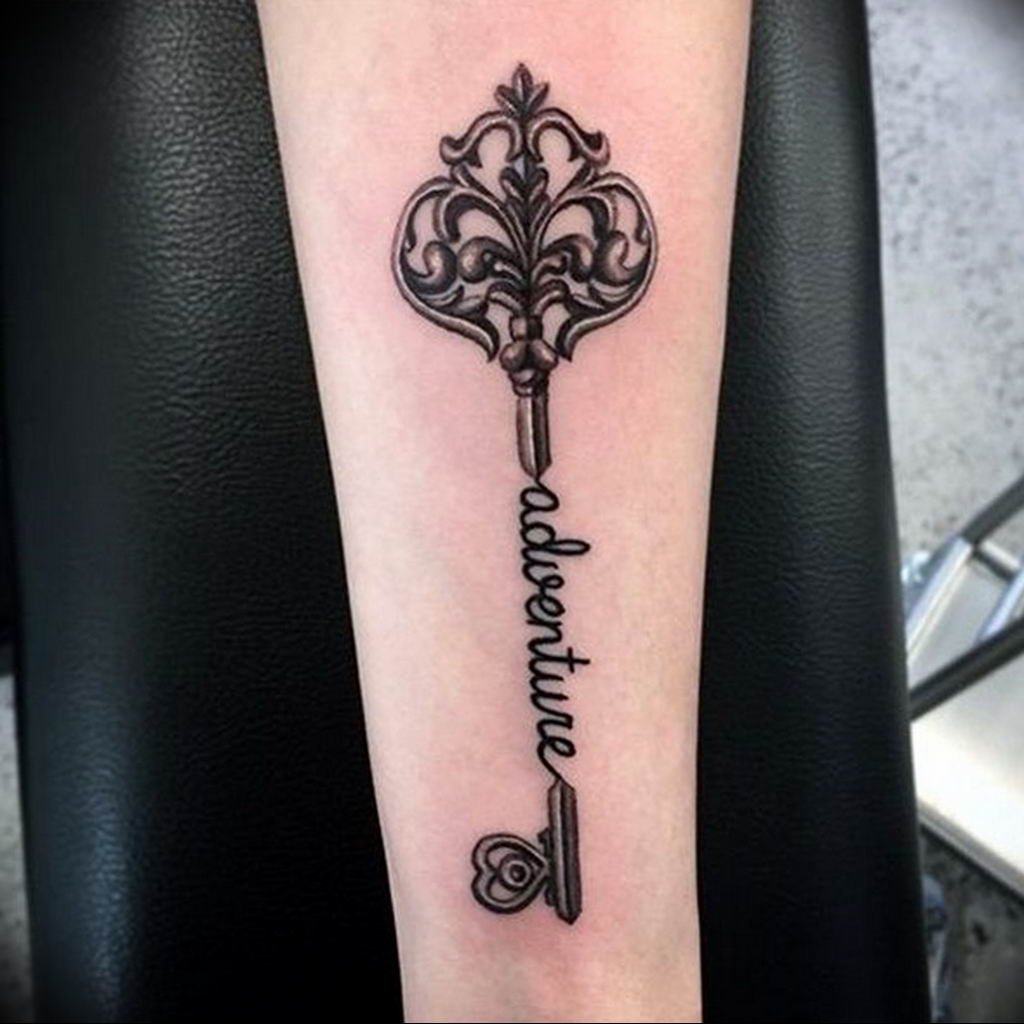 Key tattoo with inscription on forearm for women