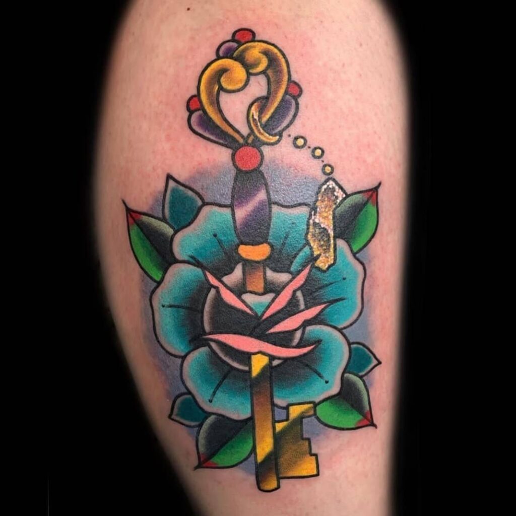 Colorful tattoo of a key with a rose on the shoulder for men