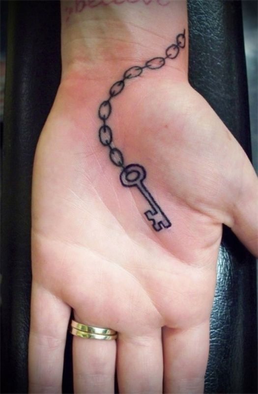 Key tattoo on the palm of the hand for women