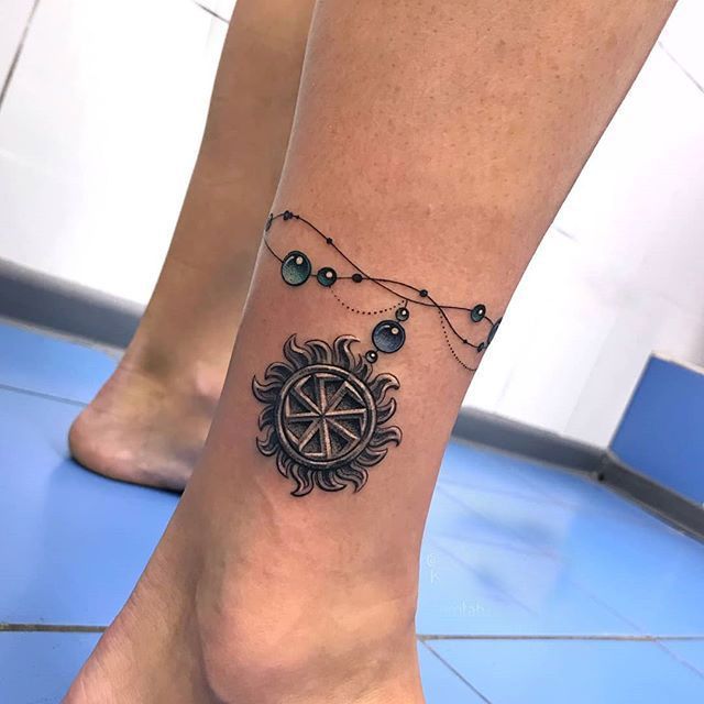 Kolovrat tattoo on lower leg for women