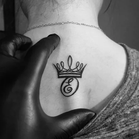 Crown tattoo on the spine for women